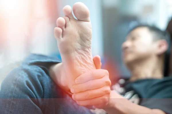 A person holding their foot in discomfort